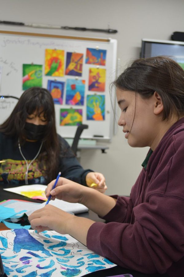 Blue hue \\ Carefully choosing their colors, freshman Cynthia Estrada and freshman Maggie Fowles work on tissue paper collages in Art I March 17. The assignment was to paint within an outline of a hand and stick tissue paper to the wet paint to create interesting textures and colors.
