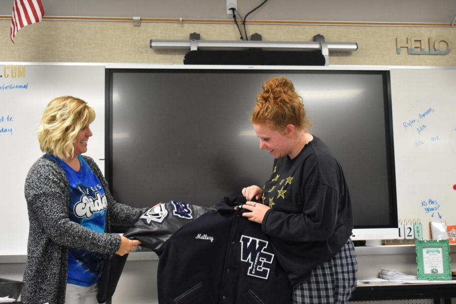 From ear to ear \ Looking at her new jacket, sophomore Mallery Koehler smiles after getting her letterman. “When I received my letterman, I was so excited and smiley because it was something I had been waiting to get for months,” Koehler said. 
