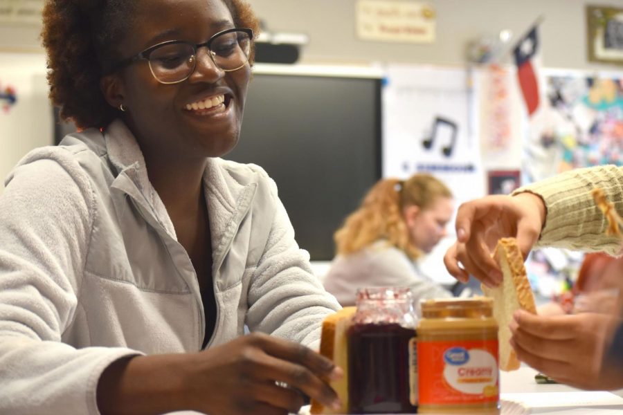Pb&j time \\ Laughing while constructing a peanut butter and jelly sandwich, senior Immanuella Olajuyigbe helps her teammates try and put together the sandwich. Students were asked to write instructions in Professor Elizabeth Simmons’ Dual Credit English class and make a peanut butter and jelly sandwich to practice procedural writing. 