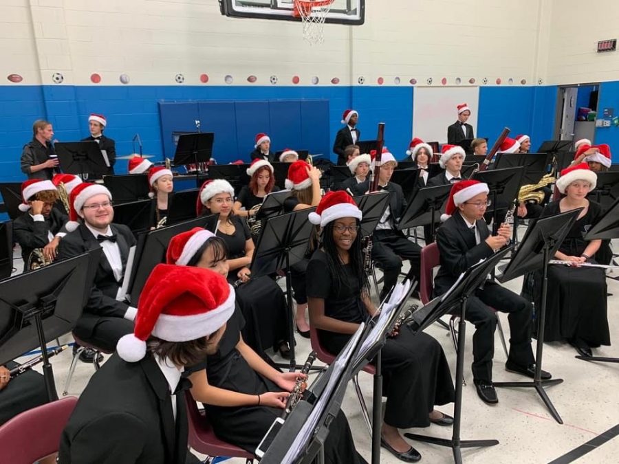 Holiday flare \\ The Wind Symphony wears their concert black clothes along with Santa hats for their Elementary Christmas tour. They played many holiday songs for all of the elementary kids. 
