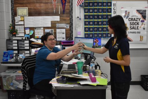 Coffee Talk \\ Surprising Mrs. Alicia Kam, junior Nadya Thung hands coffee over as part of NHS’s East Coffee Co. The shop opened to teachers Friday, March 4. “This really shows that NHS cares about the teachers at East,” Thung said. “It also was a great mood lifter for the last day of school before spring break!”