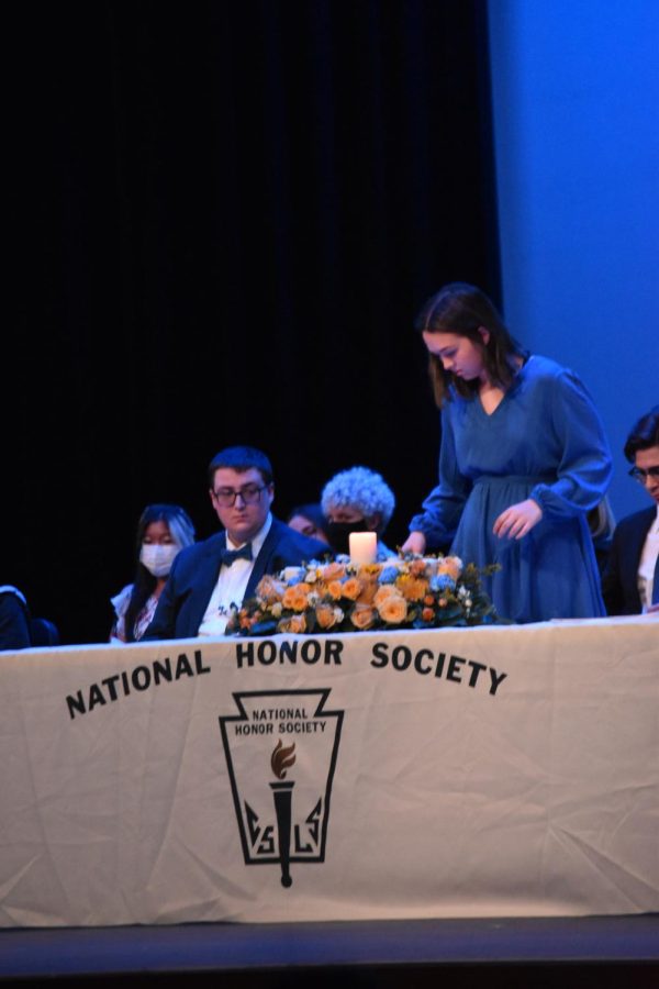 Call the Shots \\ Lighting her candle, Treasurer Emily Combest, puts a start to the NHS ceremony Nov. 15. Each officer lit a candle on the table to signify the four criteria: scholarship, service, leadership and power. “I love getting to facilitate events as an officer to help my classmates and the community,” Combest said.