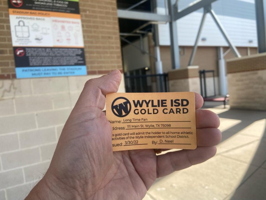 Calling Card \\ Wylie ISD Communications Director Ian Halperin holds up an example gold card that some residents can apply for to get free admission to certain district events. The program is open to anyone 65 years of age or older, a retired Wylie ISD teacher of any age, and more recently, active-duty military personnel or veterans.“Students love to play and perform to a full house. Having fans in the audience makes for a fun atmosphere and in sports, a home-court advantage,” Halperin said.