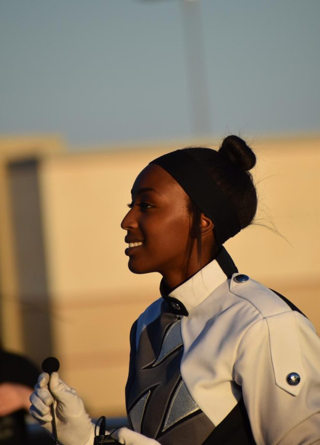 Follow the leader \\ Smiling at her bandmates, senior Celine Abuga gives the band instructions on District Band Night  Oct 20.