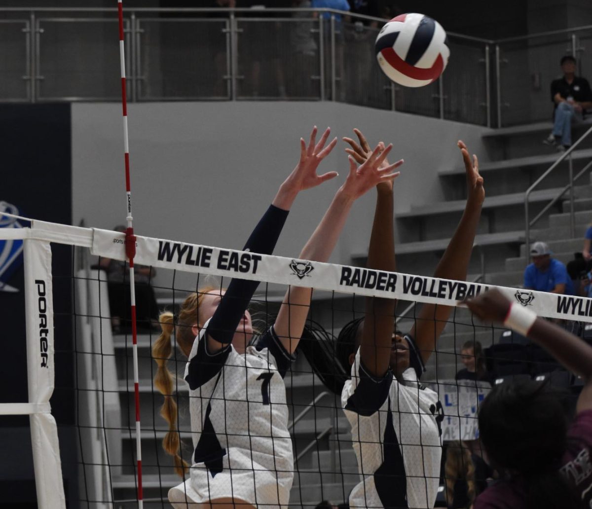 Ricochet right-side \ In a synchronized block formation, senior Dayden Dyess (left) along side her fellow hitters helps lead the Varsity Volleyball team to victory during the crosstown showdown game Sept. 12. They continue their 7-0 streak as they approach play-off season. My favorite memory from the game was winning game point in the last set, Dyess said. We blew them out, winning 15-2.