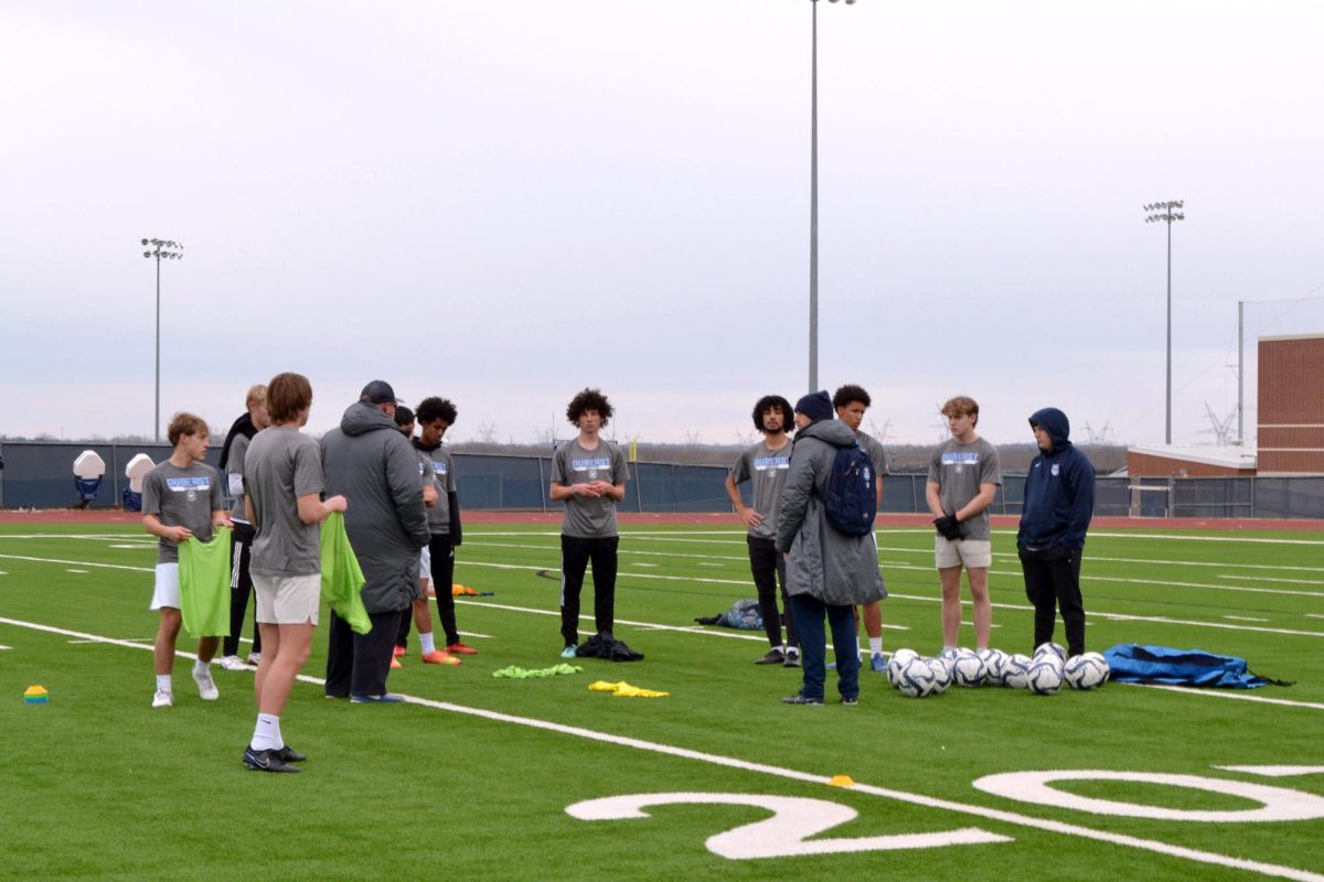 Tellin%E2%80%99+it+how+it+is+%5C%5C+Boys+head+soccer+coach+and+anatomy+and+physiology+teacher+Trey+Vaut+%28in+the+blue+beanie%29+directs+the+drill+during+morning+practice+March+6.+This+school+year+marked+his+11th+year+as+a+high+school+soccer+head+coach.+%E2%80%9CI+learn+every+year+from+my+players+because+you+have+different+types+of+kids%2C+personalities+%5Band%5D+things+like+being+able+to+communicate+with+them+correctly+what+you%E2%80%99re+trying+to+teach+them+and+to+be+open%2C%E2%80%9D+Vaut+said.+