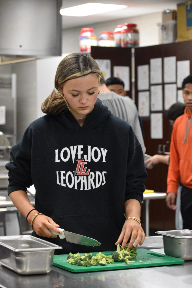 Mincing menace \\ Cutting broccoli, Addison Whittley practices proper knife techniques to improve her overall cooking skills.“ [I most enjoy] the experiences and the things I have learned along the way,” Whitley said.