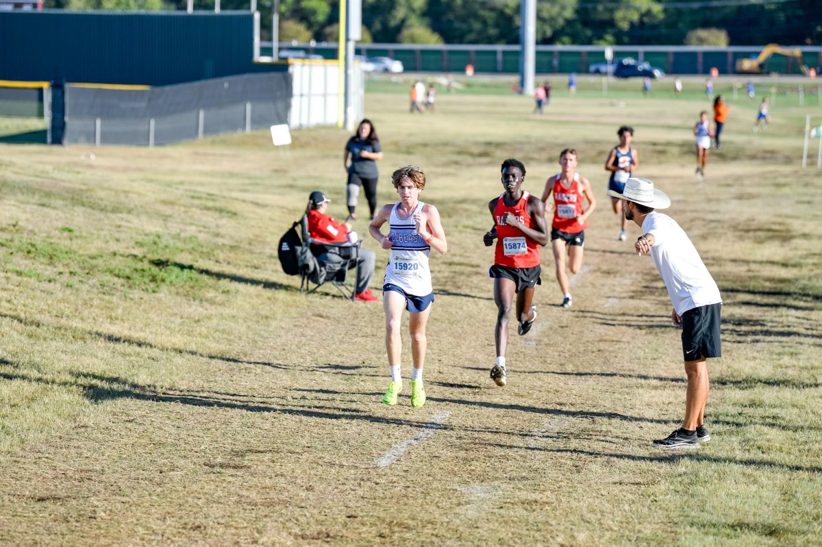 Chasin%E2%80%99+after+it+%2F%2F+Head+cross+country+coach+and+geometry+teacher+Luke+Scribner+encourages+varsity+runner+Keigan+Trussell+during+the+district+meet+Oct.+6.+This+school+year+marked+his+seventh+year+coaching+both+cross+country+and+track.+%E2%80%9CI%E2%80%99m+just+super+excited+to+be+here+and+glad+to+see+the+development+we%E2%80%99ve+seen+in+the+short+bit+of+time+of+me+being+here%2C%E2%80%9D+Scribner+said.+