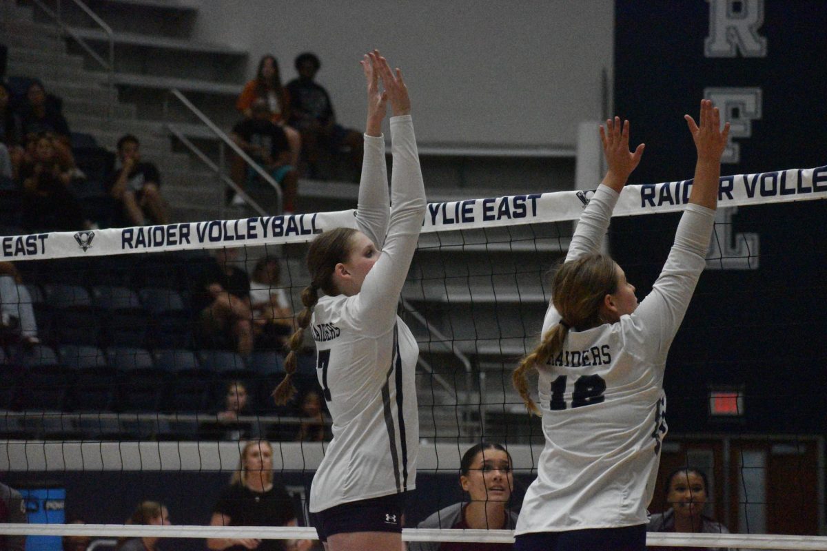 Spike to Victory // Emma Ball and teammate Morgan King jump to block the ball during a junior varsity game against Plano Senior on Aug 20 2024. The teammates worked together to ensure a victory. “I love playing with my team,” Ball said. 
