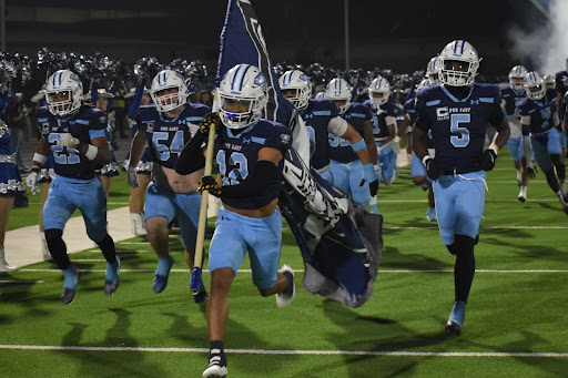 East Side Triumph // During the beginning of the Wylie East vs. Wylie High game Nov. 7, the varsity football team runs down the field as their entrance run out with smoke machines pumping and drill team cheering. Senior Jayden Janshego and his teammates were ready for the big game. “My favorite part was winning with my brother and my teammates,” Janshego said. Wylie East won 23-6.
